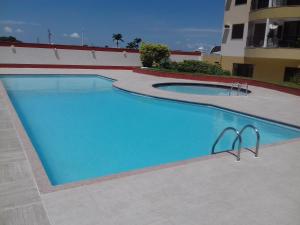 a large swimming pool next to a building at Suíte aconchegante no Centro de Campos WIFI Liberado in Campos dos Goytacazes