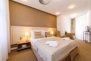 A bed or beds in a room at BEIGLI Hotel & Garden