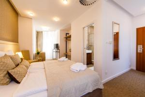 A bed or beds in a room at BEIGLI Hotel & Garden
