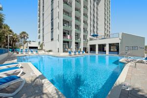 默特尔比奇Ocean Park Resort - Oceana Resorts Vacation Rentals的一个带椅子的大型游泳池和一栋建筑