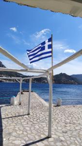 a american flag flying on a pier next to the water at Afrodite Luxury Rooms in Kalymnos