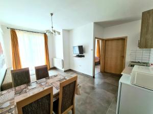 a kitchen with a table and chairs in a room at Regina Apartman Hegykő in Hegykő