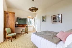 a bedroom with a bed and a desk and a television at Manoir du Guern in Pluvigner +41 photos