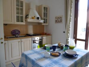 una cucina con tavolo e tovaglia blu e bianca di A 20 mt dal mare con ombrellone e sdraio in spiaggia a Castiglioncello