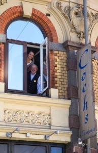 a man and a woman looking out of a window at Cochs Pensjonat in Oslo