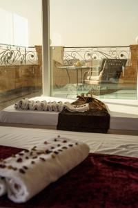 a bedroom with a bed and a window with a table at Gardenia Pyramids view inn in Cairo