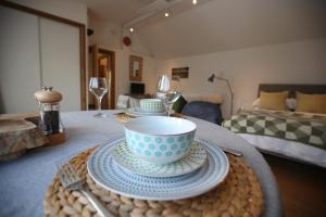 a table with a bowl and plates and wine glasses at Garden Studio in Biggar in Biggar