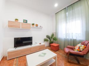 a living room with a tv and a couch and a table at Casa Maria Luisa | +Patio in Barbate