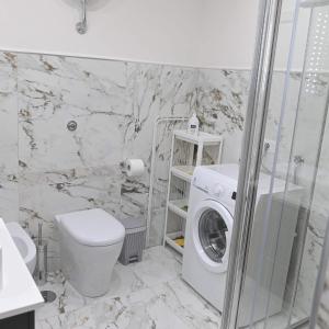 La salle de bains est pourvue d'un lave-linge et de toilettes. dans l'établissement Apartament Regina Elena, à Torre Annunziata