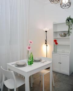 a white dining room table with two chairs and flowers on it at Florence Chic, garden and parking in Florence