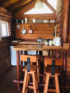 una cocina con mesa de madera y sillas en una cabaña en Cabanas Los Troncos en San Pedro
