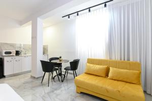 a living room with a yellow couch and a table at Lake Mansion Boutique Apartments in Tiberias
