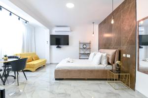 een slaapkamer met een bed, een bank en een tafel bij Lake Mansion Boutique Apartments in Tiberias
