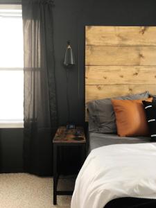 a bedroom with a bed with a wooden headboard and a table at the218 on 7th in Grand Rapids