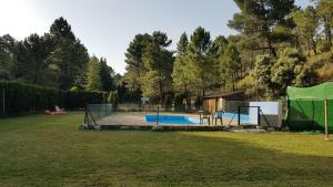 a yard with a swimming pool with a fence at La cabaña del lago en ZAFIRO LAGUNAZO Parque Natural del Río Mundo in Riópar