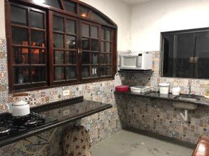 a kitchen with a stove and a microwave at Residencial Beira Mar Cananéia in Cananéia