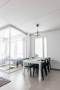 - une salle à manger blanche avec une table et des chaises blanches dans l'établissement Apartment, Sleepwell, Tikkurila with private sauna, 70m2 1-7 pers, à Vantaa