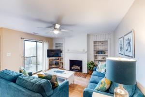 a living room with two blue couches and a tv at The Wright Place in Kitty Hawk