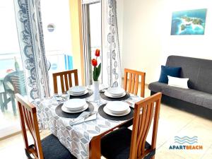 a dining room table with chairs and a couch at APARTBEACH GOLDEN I MUY LUMINOSO JUNTO PLAYA y CLIMATIZADO in Salou