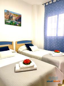 a room with three beds with red roses on them at APARTBEACH GOLDEN I MUY LUMINOSO JUNTO PLAYA y CLIMATIZADO in Salou