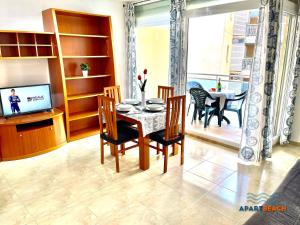a dining room with a table and chairs and a television at APARTBEACH GOLDEN I MUY LUMINOSO JUNTO PLAYA y CLIMATIZADO in Salou