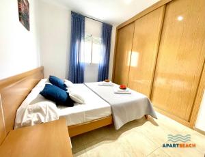 a bedroom with a large bed with blue pillows at APARTBEACH GOLDEN I MUY LUMINOSO JUNTO PLAYA y CLIMATIZADO in Salou