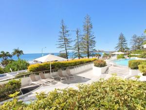 a resort with a pool and chairs and the ocean at Sirocco 202 in Mooloolaba