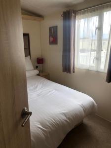 ein Schlafzimmer mit einem weißen Bett und einem Fenster in der Unterkunft Emmanuel Holiday Home in Whitley Bay