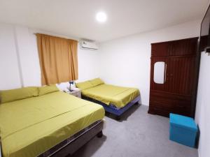 um quarto de hotel com duas camas e uma cómoda em Hostal El Naufrago 1 em Manta