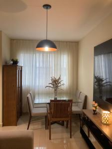 a living room with a table and a couch and a dining room at Apartamento aconchegante. in Petrolina