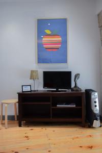 a living room with a television and an apple painting at Aurora Garden in Porto