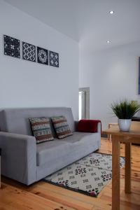 Sala de estar con sofá gris y mesa en Aurora Garden, en Oporto