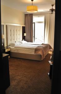 een slaapkamer met een groot bed met een groot raam bij Hotel Atlas Halle in Halle an der Saale +76 foto's