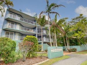 a building with palm trees in front of it at Mainsail 3 in Mooloolaba