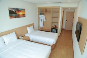 Cette chambre comprend 2 lits et une télévision. dans l'établissement Gold Boutique Hotel Danang, à Đà Nẵng