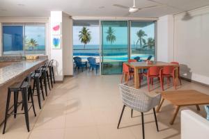 un restaurant avec des tables et des chaises et une vue sur l'océan dans l'établissement Magico Apartamento Frente al Mar 3 Habitaciones PAZ222, à Coveñitas