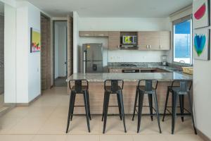 - une cuisine avec quatre tabourets de bar et un réfrigérateur dans l'établissement Magico Apartamento Frente al Mar 3 Habitaciones PAZ222, à Coveñitas 40 autres photos