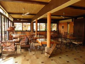 restauracja ze stołami, krzesłami i oknami w obiekcie Le Dakan w mieście Saly Portudal