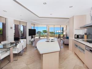 a kitchen and living room with a view of the ocean at Oceans 201 luxurious beachfront apartment in Mooloolaba