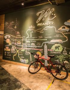 a bike parked in front of a wall with a map at Meander Taipei Hostel - Ximending in Taipei
