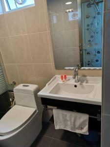 a bathroom with a white toilet and a sink at Palace Inn in Miri