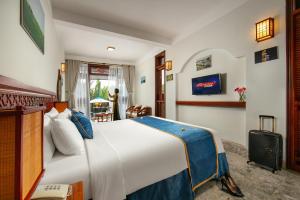 sypialnia z dużym łóżkiem w pokoju w obiekcie Hoi An Riverside Villas & Apartments w Hoi An