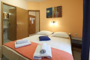 a bedroom with a bed with towels on it at La Familia Apartments in Makarska