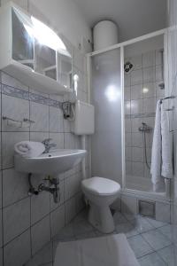 y baño con aseo, lavabo y ducha. en La Familia Apartments, en Makarska