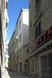 an alley with a building with a sign on it at La Familia Apartments in Makarska