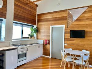 a kitchen with wooden walls and a table and chairs at The Morrison Stables in Geelong