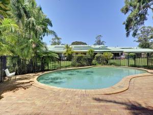 a swimming pool in a yard with a fence at 30 Bay Parklands in Nelson Bay