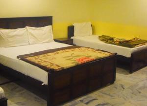 two beds in a room with two at Hotel Khursheed Palace in Rawalpindi