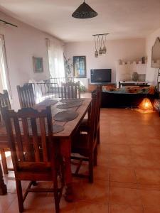 comedor con mesa de madera y sillas en Casa rural La Casita del Arte, en Robledo de Chavela