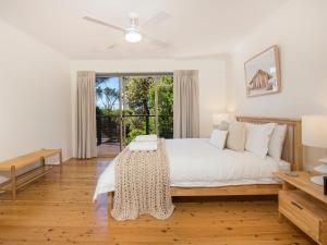 um quarto com uma cama e uma grande janela em Surfspray I Pet Friendly I Absolute Beachfront em Culburra Beach